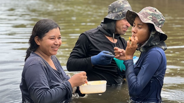 Baumpflanzerinnen lachend hüfthoch im Wasser